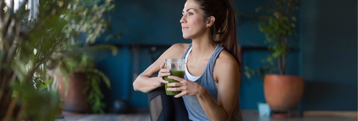 Woman holding green juice