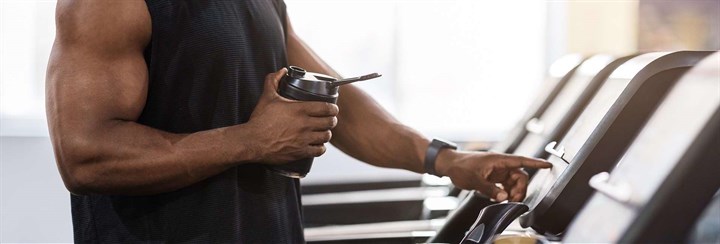 Man holding sports bottle on treadmill