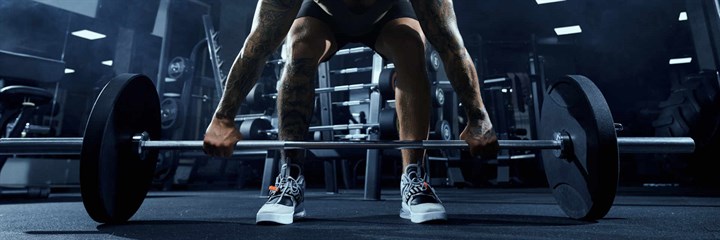 Man lifting barbell weight in gym