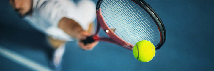 Man hitting tennis ball with racket