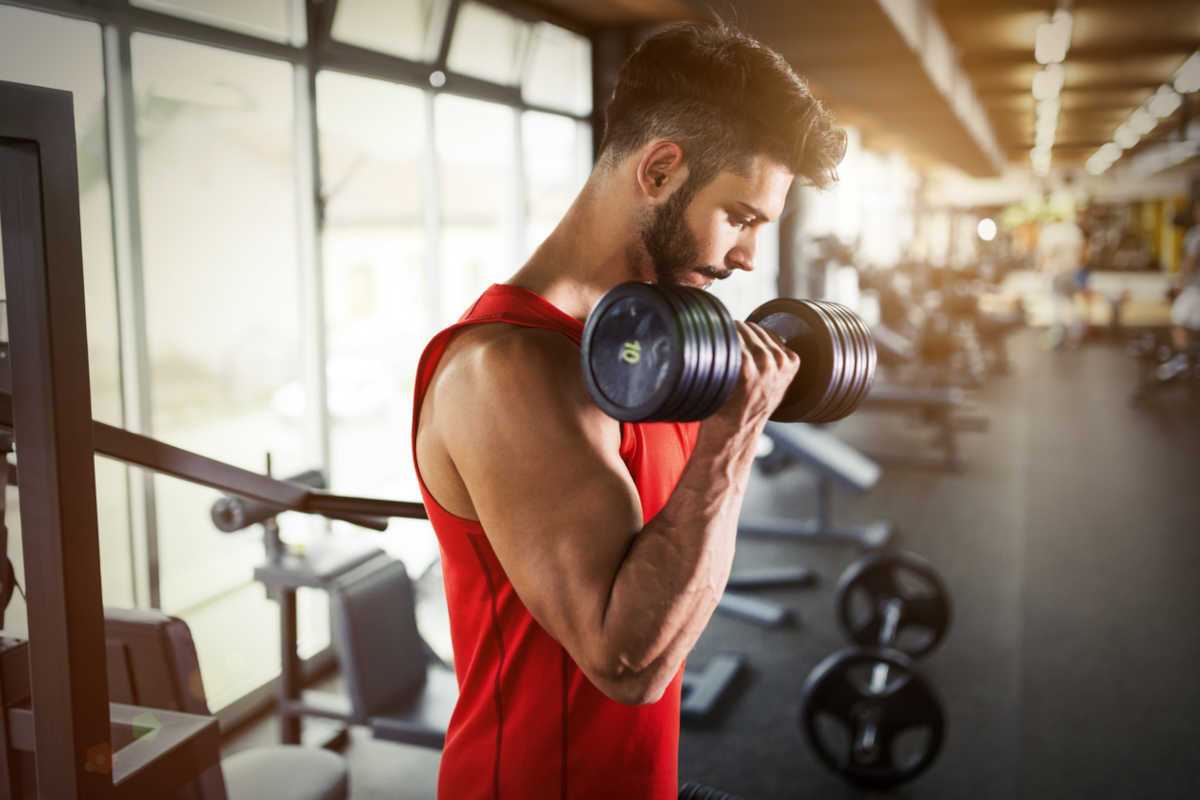 Man in red top lifting arm weight