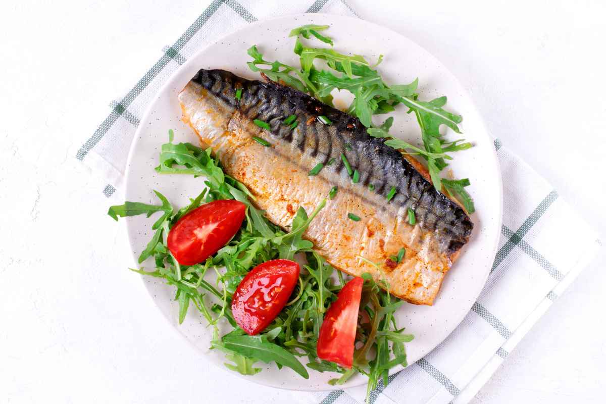 Overhead photo of oily fish and vegetables on a plate