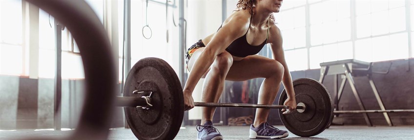 Woman lifting barbell in the gym