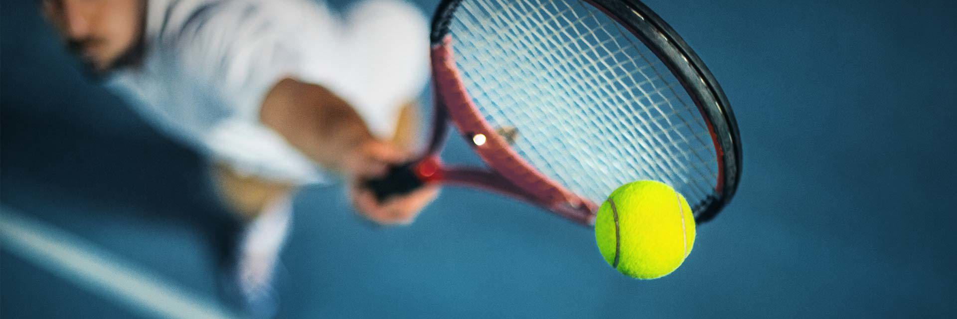 Man hitting tennis ball with racket